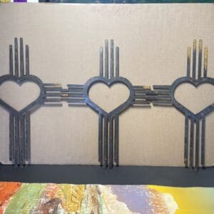 Three heart shaped metal sculptures on top of a cardboard box.