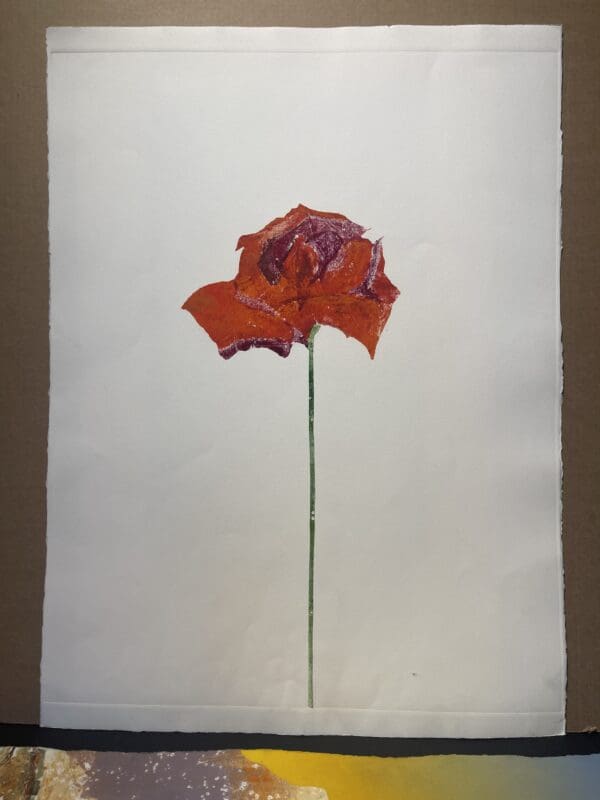 A painting of a red flower on a piece of paper.
