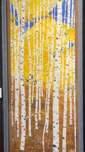 Framed painting of a birch forest.